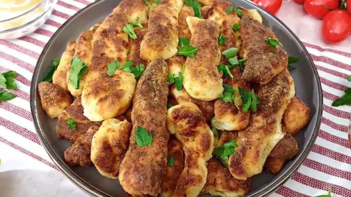A plate full of bread sticks and tomatoes.