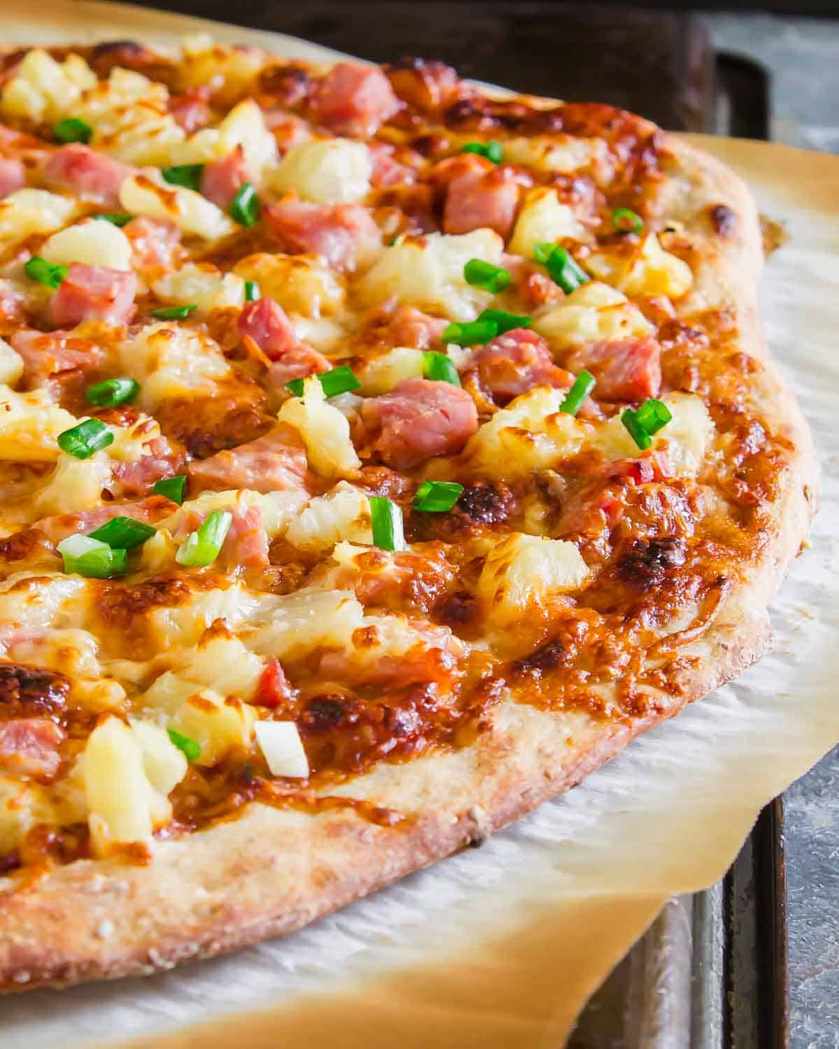 A ham and pineapple pizza on a tray.