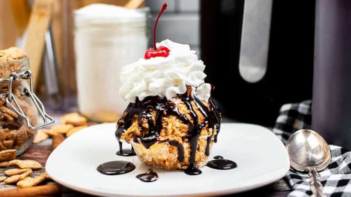 Fried ice cream scoop topped with whipped cream and chocolate sauce.