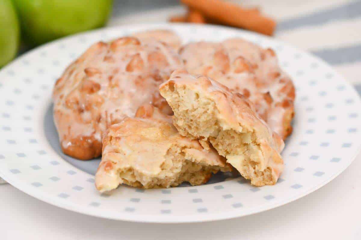 Apple cinnamon fritters on a plate with apples.