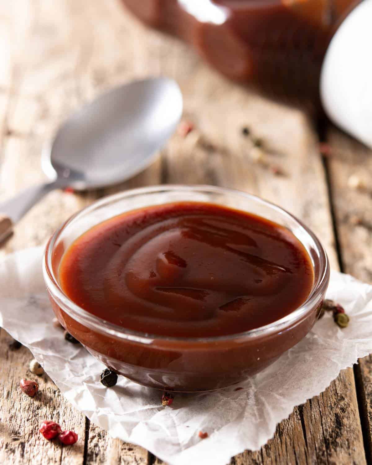 Bbq sauce in a bowl on a wooden table.