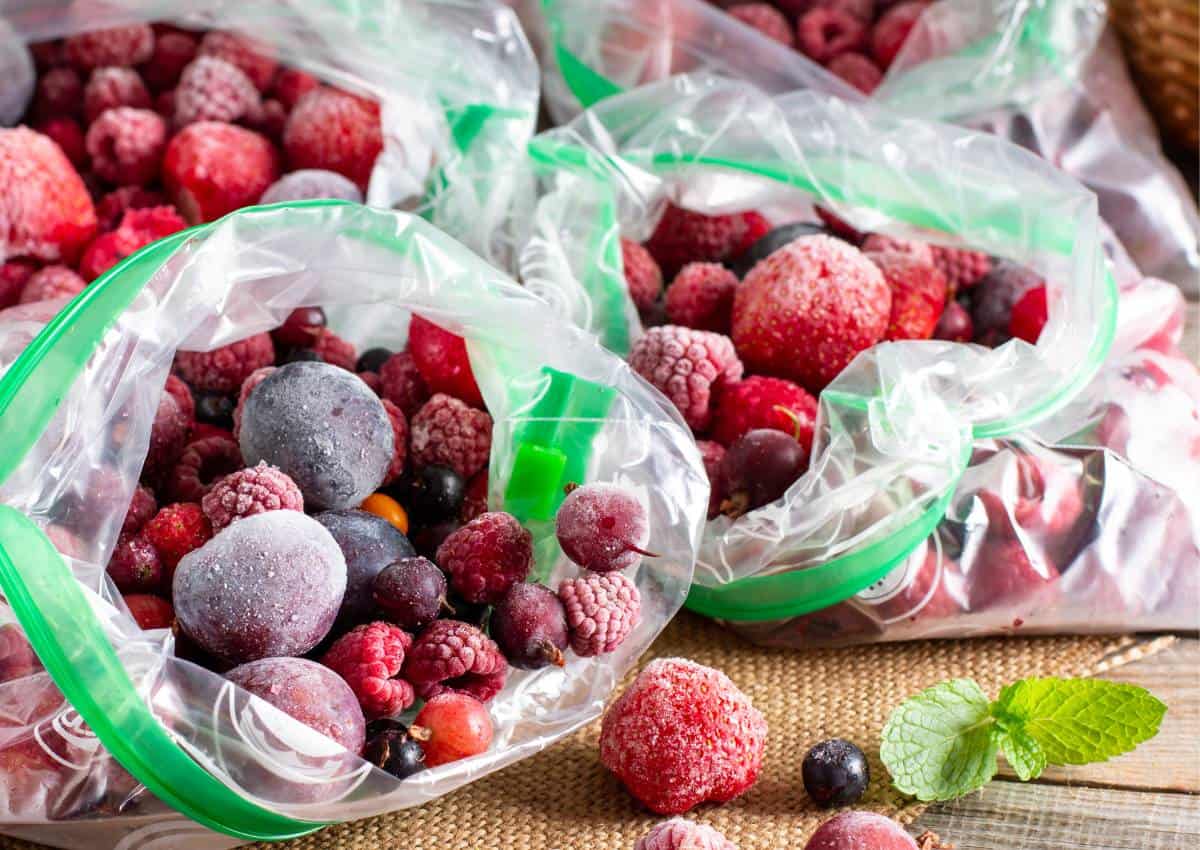 Frozen berries in plastic bags on a wooden table.