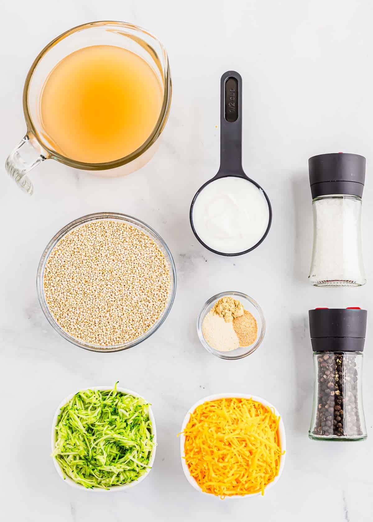 The ingredients for a quinoa side dish are laid out on a white surface.