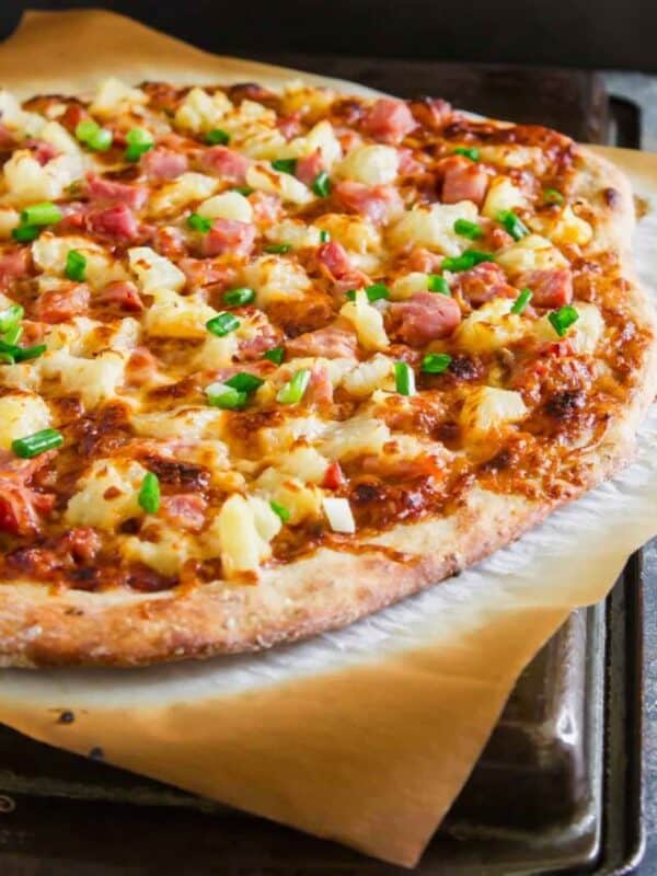 A pizza with ham and pineapple on top.