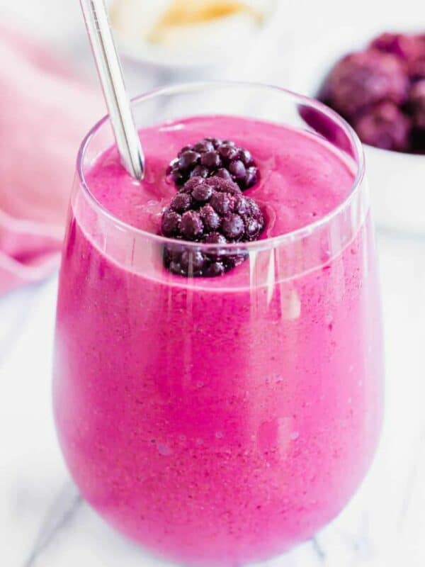 A pink smoothie with blackberries and bananas.