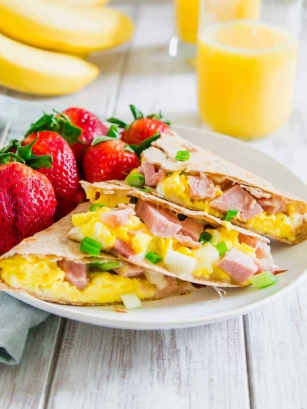 A plate with a breakfast burrito on it.