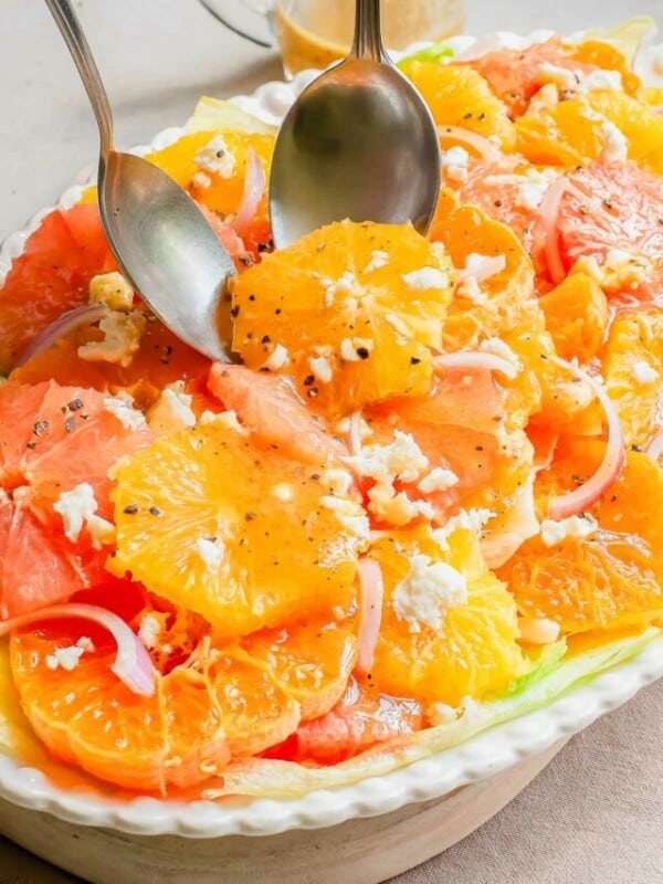 A salad with oranges and feta cheese on a plate.
