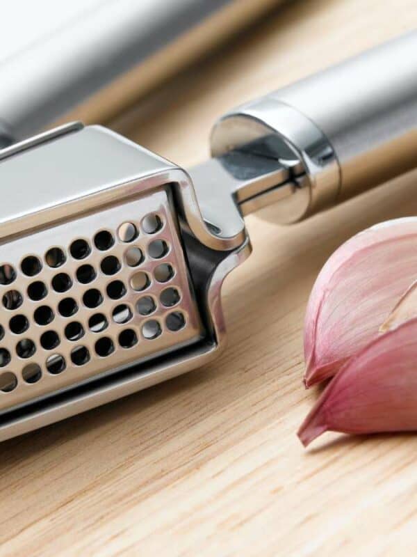 Garlic grater on a wooden cutting board.