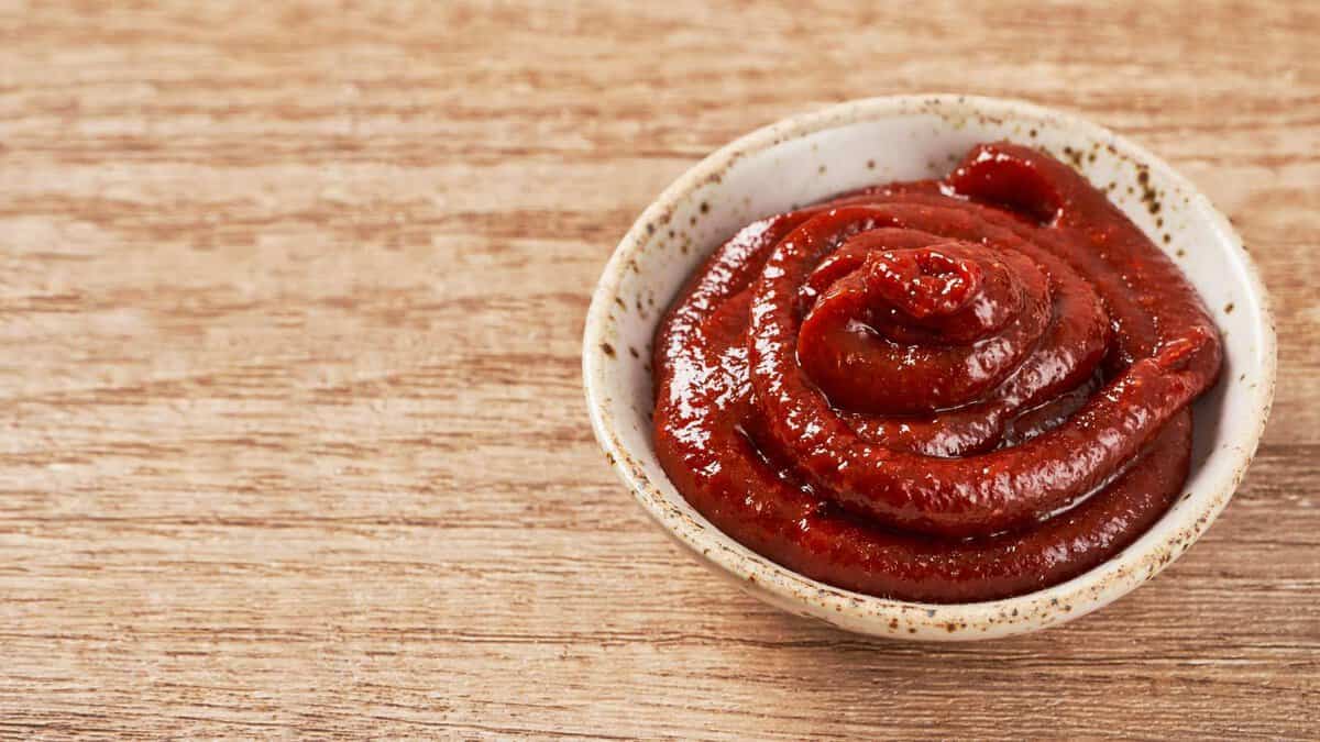 Gochujang in a bowl on a wooden table.