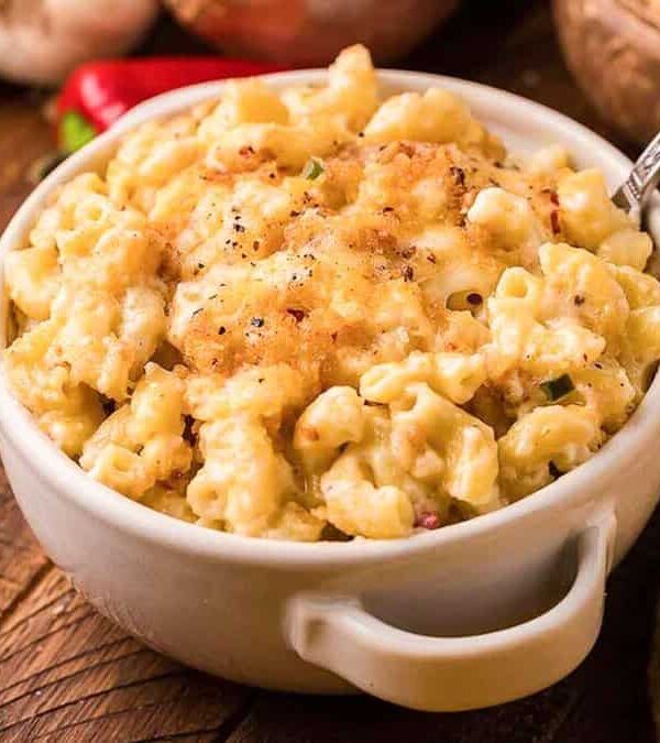 Two bowls of macaroni and cheese on a wooden table.