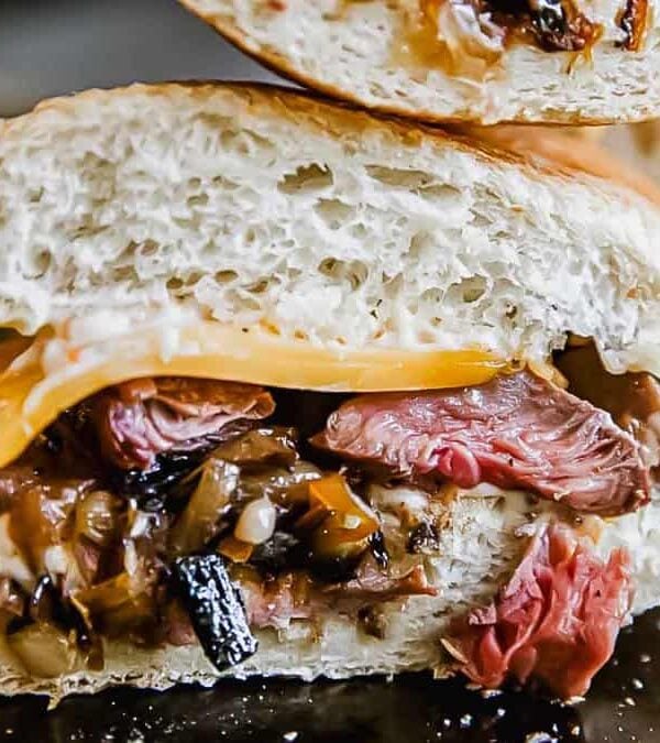 A sandwich with beef, onions and cheese.