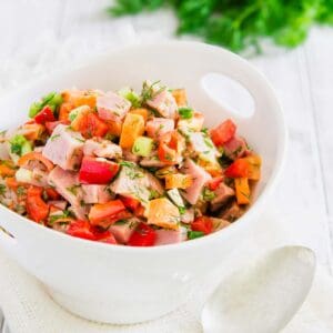 Chopped ham salad in a white bowl with a spoon.