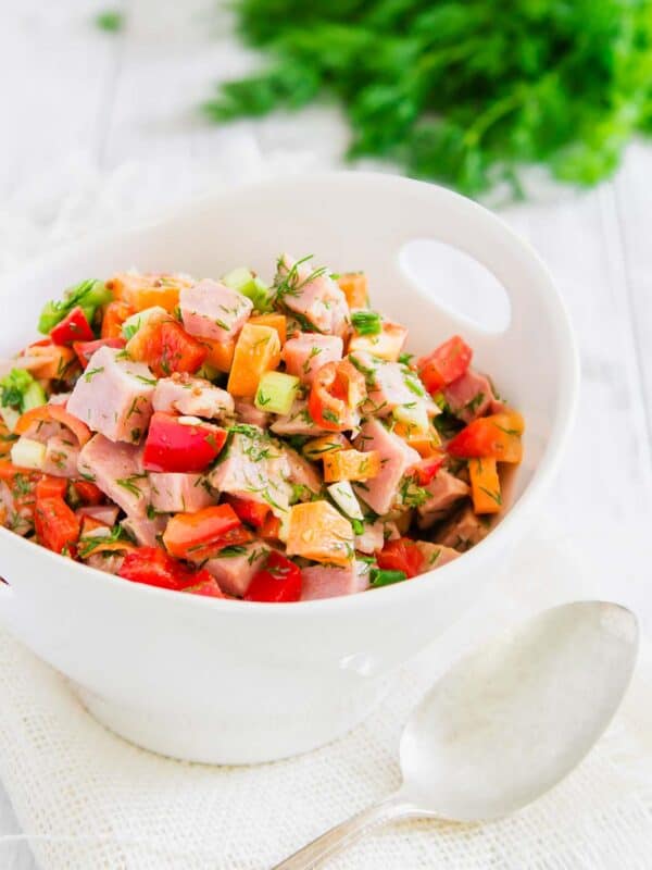 Chopped ham salad in a white bowl with a spoon.