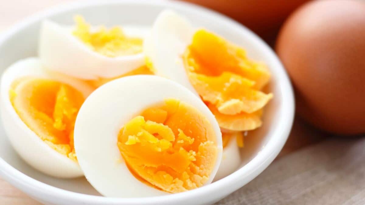 Hard boiled eggs in a bowl on a wooden table.