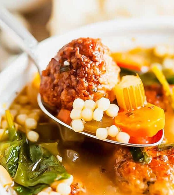 A bowl of soup with meatballs and vegetables.
