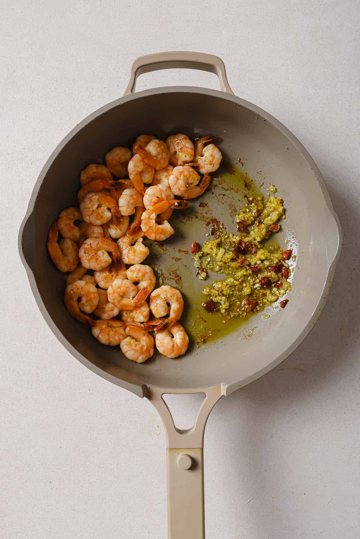 A frying pan with shrimp and garlic in it.