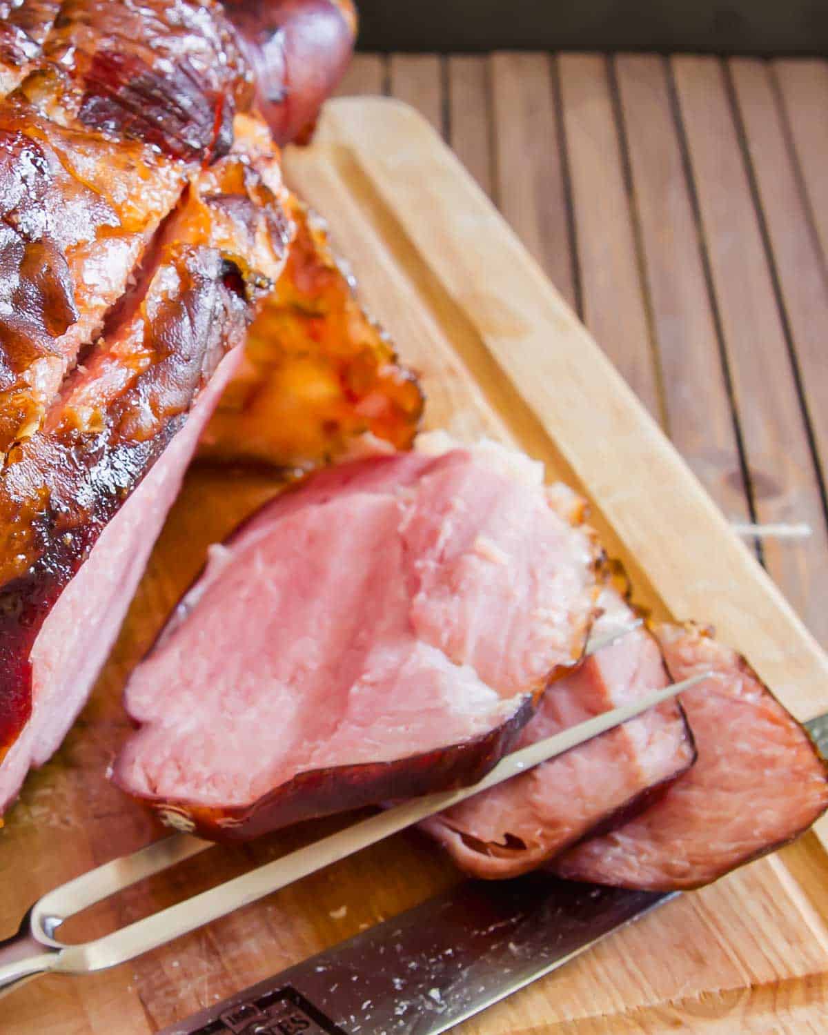 Whole ham on a cutting board.