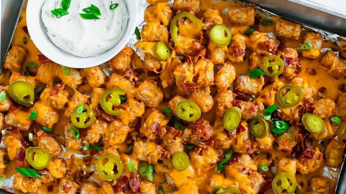 A tray of loaded tater tots with cheese and jalapenos.