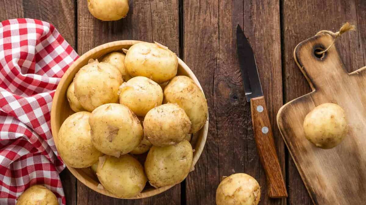 Potatoes in a wooden bowl on a wooden table.