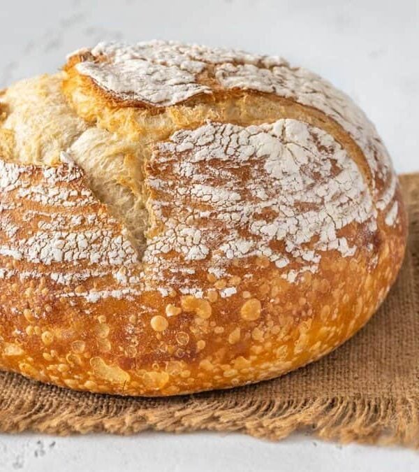 A loaf of bread sitting on a burlap cloth.