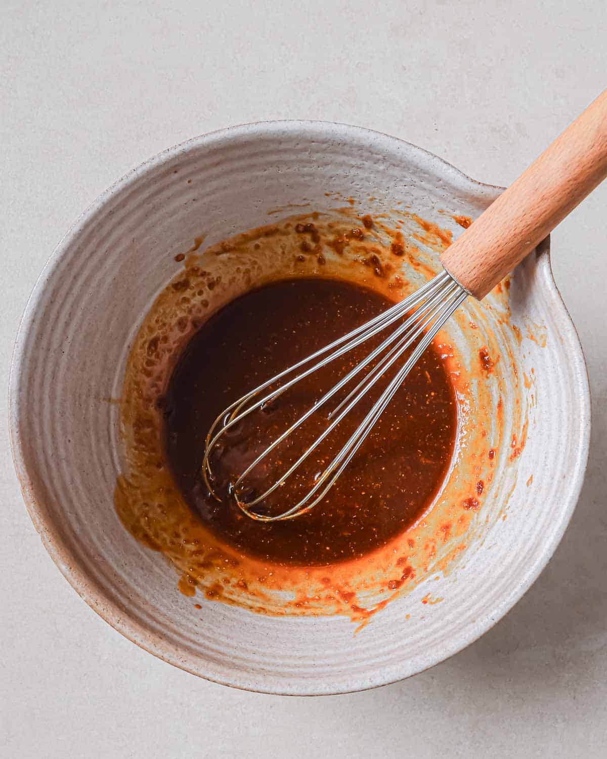 Fried rice sauce in a bowl with a whisk.