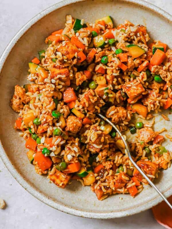 Tofu fried rice on a dish with a fork.