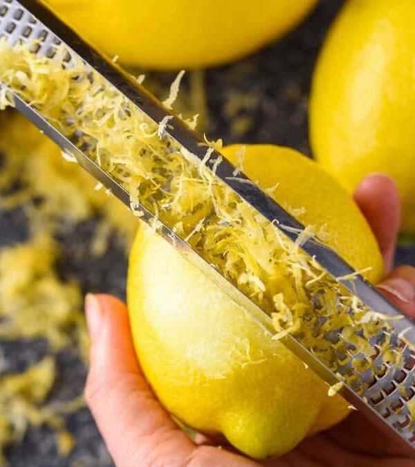 A person is grating lemons with a grater.