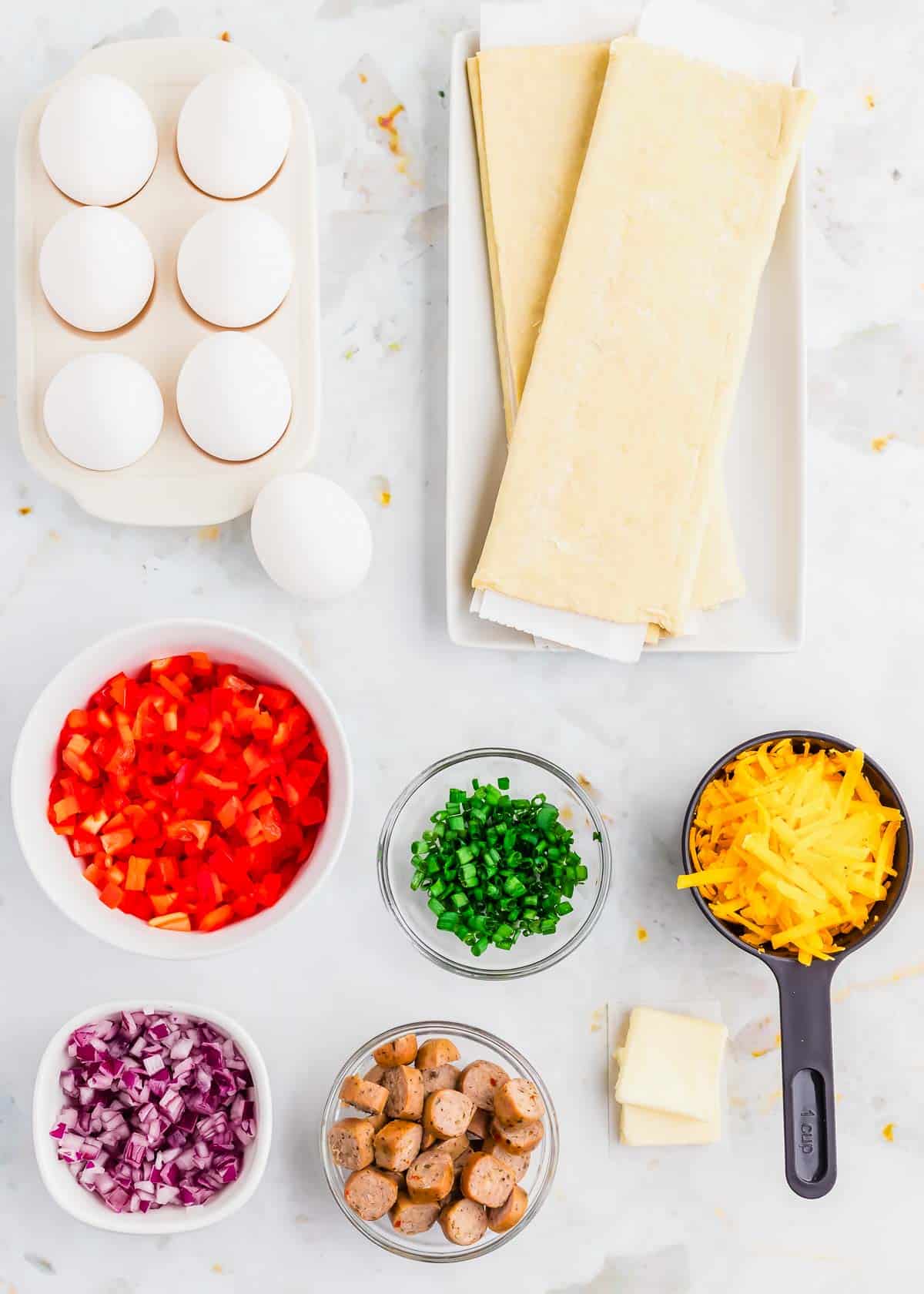 The ingredients for a breakfast hot pockets are laid out on a marble countertop.