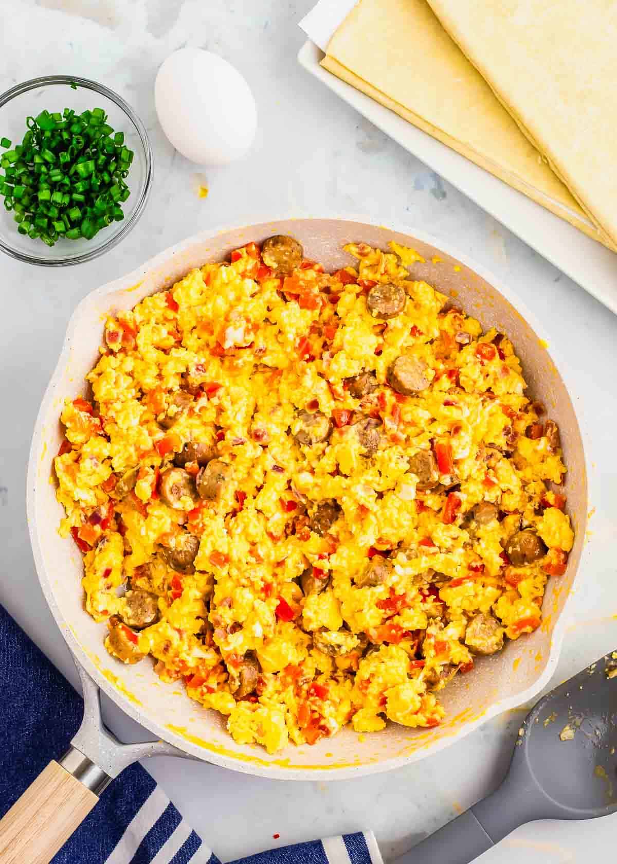 A skillet filled with scrambled eggs and vegetables.