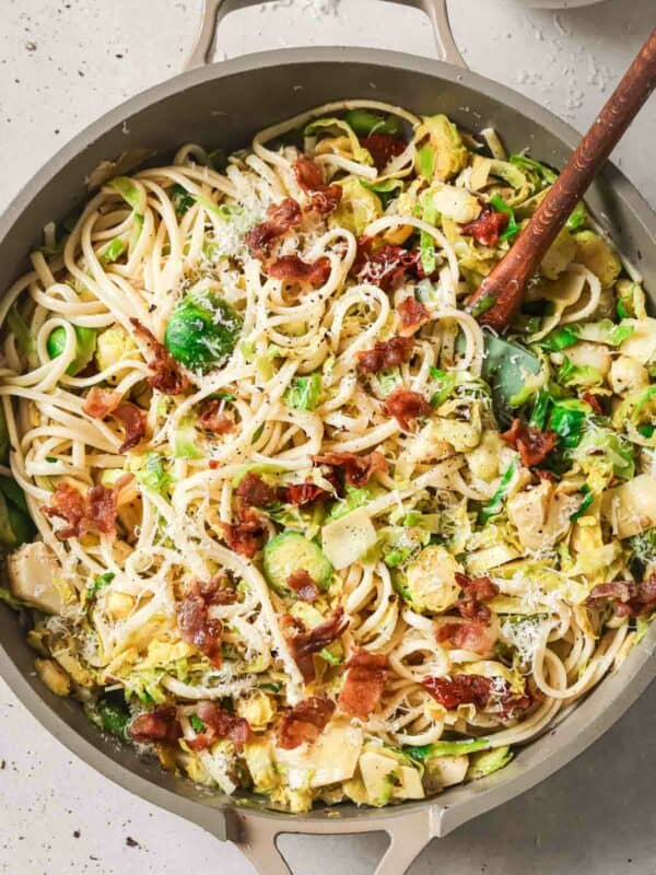 A skillet filled with pasta, bacon and brussels sprouts.