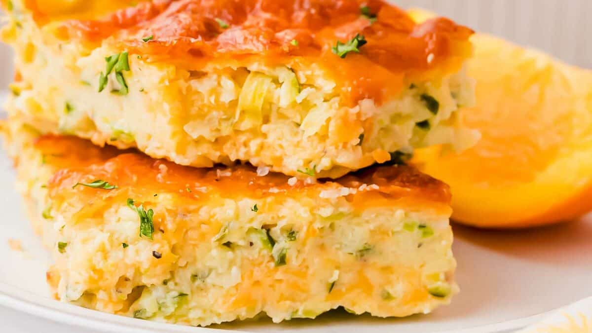 A plate of cheesy zucchini casserole on a white plate.