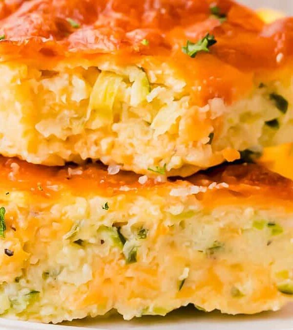 A plate of cheesy zucchini casserole on a white plate.