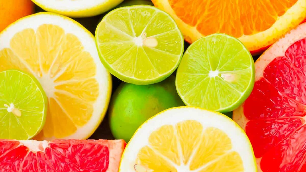 A close up of oranges, limes, and grapefruits.