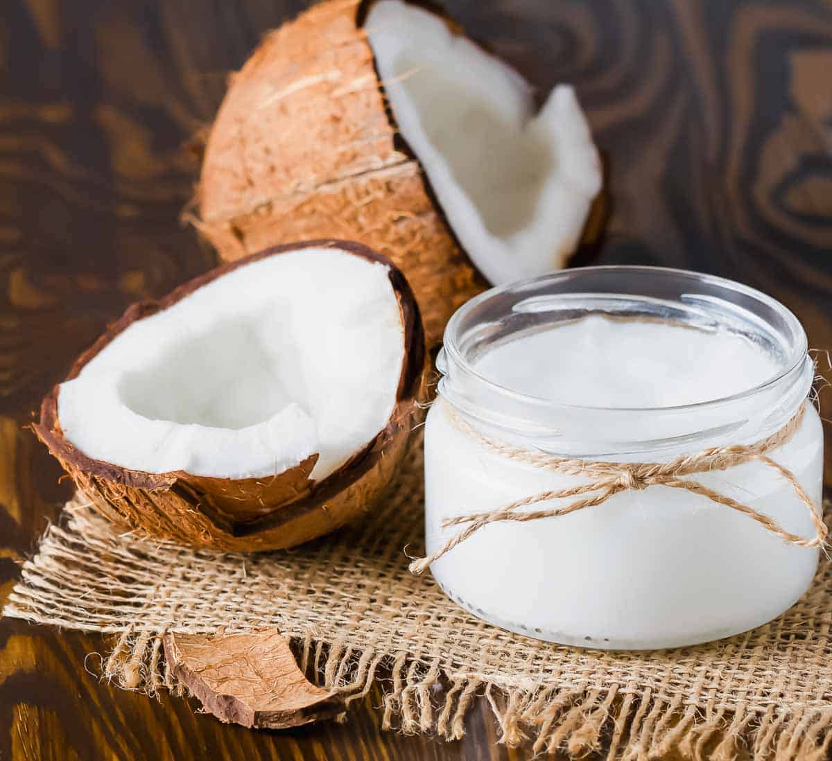 Coconut oil in a jar on a wooden table.