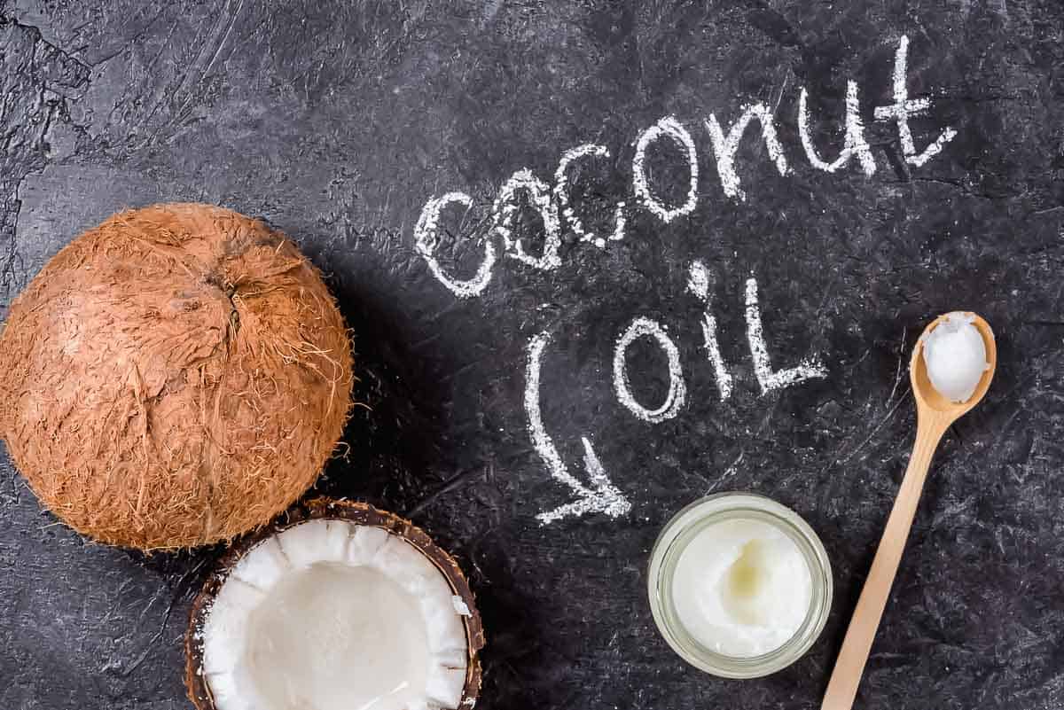 Coconut oil and a spoon on a black background.