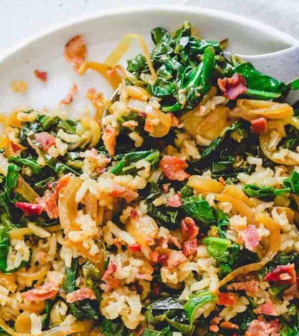 A plate of spinach and bacon with a fork.