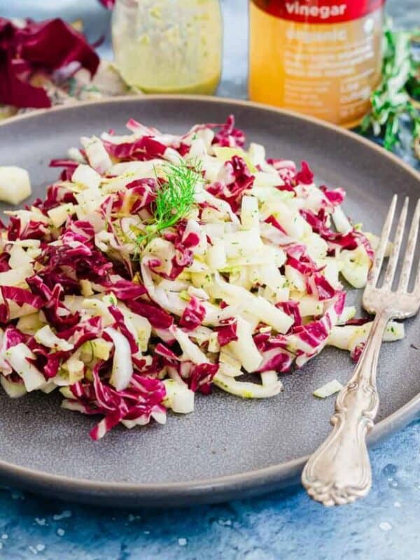 Red cabbage slaw on a plate with a fork.