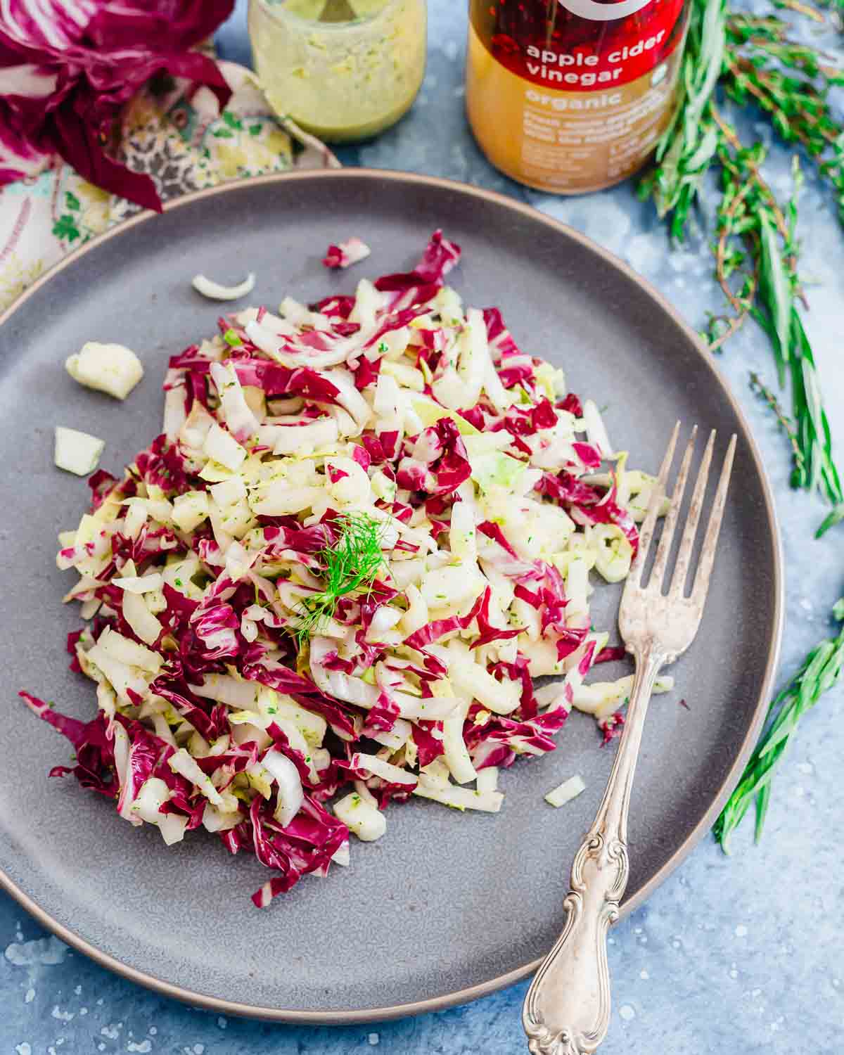 Endive, radicchio and fennel salad on a blue plate.