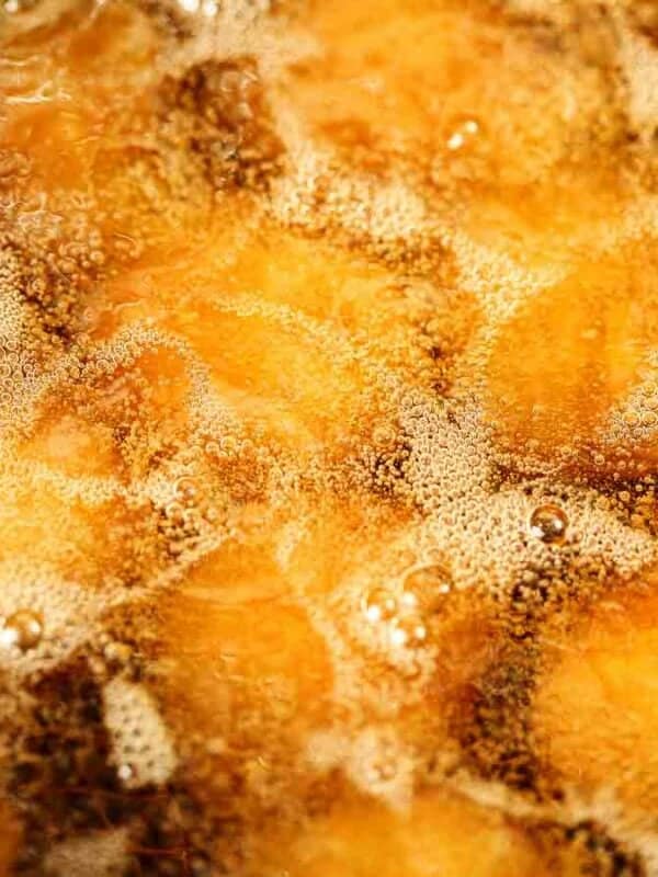 A close up of fried food in a fryer.