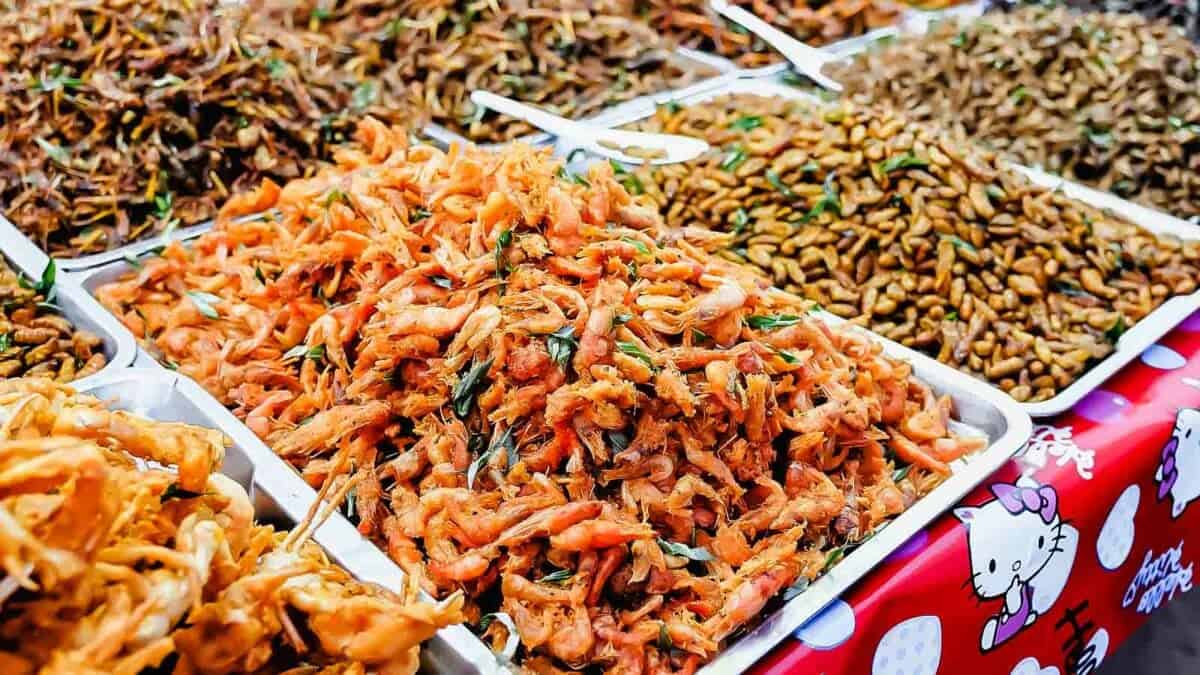 A variety of fried foods are on display at a market.