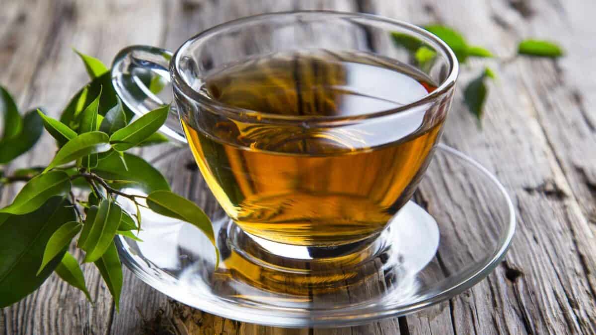 A cup of green tea on a wooden table.