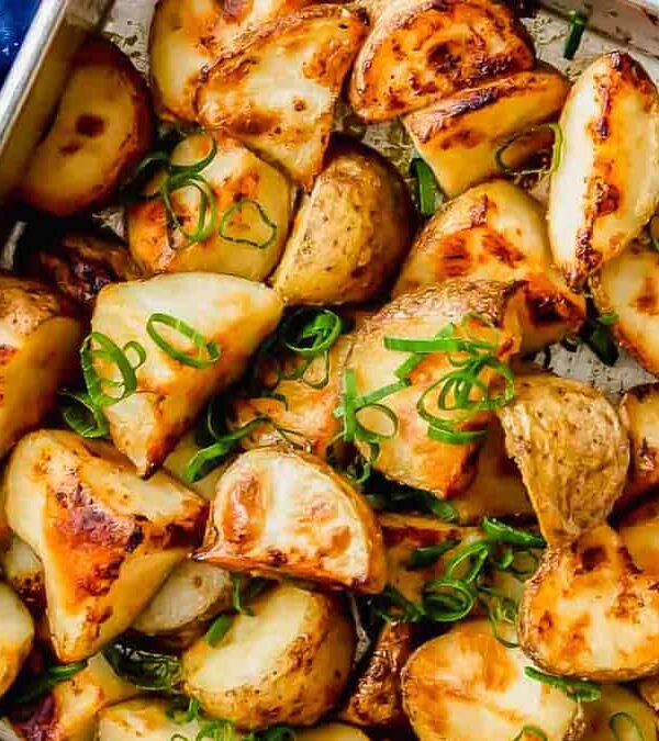 Roasted potatoes in a baking dish on a blue cloth.
