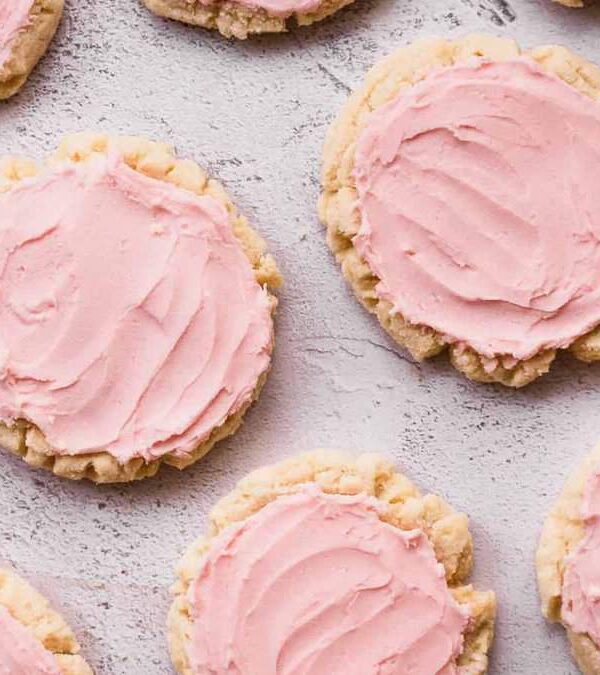 Pink frosted Valentine cookies on a white background.