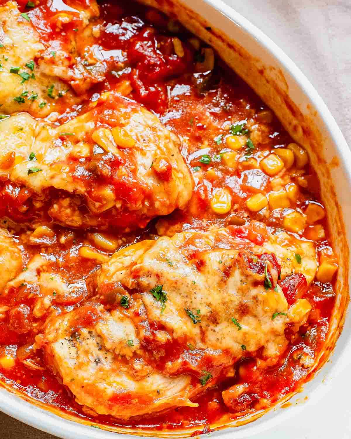 Close up of a casserole dish filled with baked salsa chicken and corn.