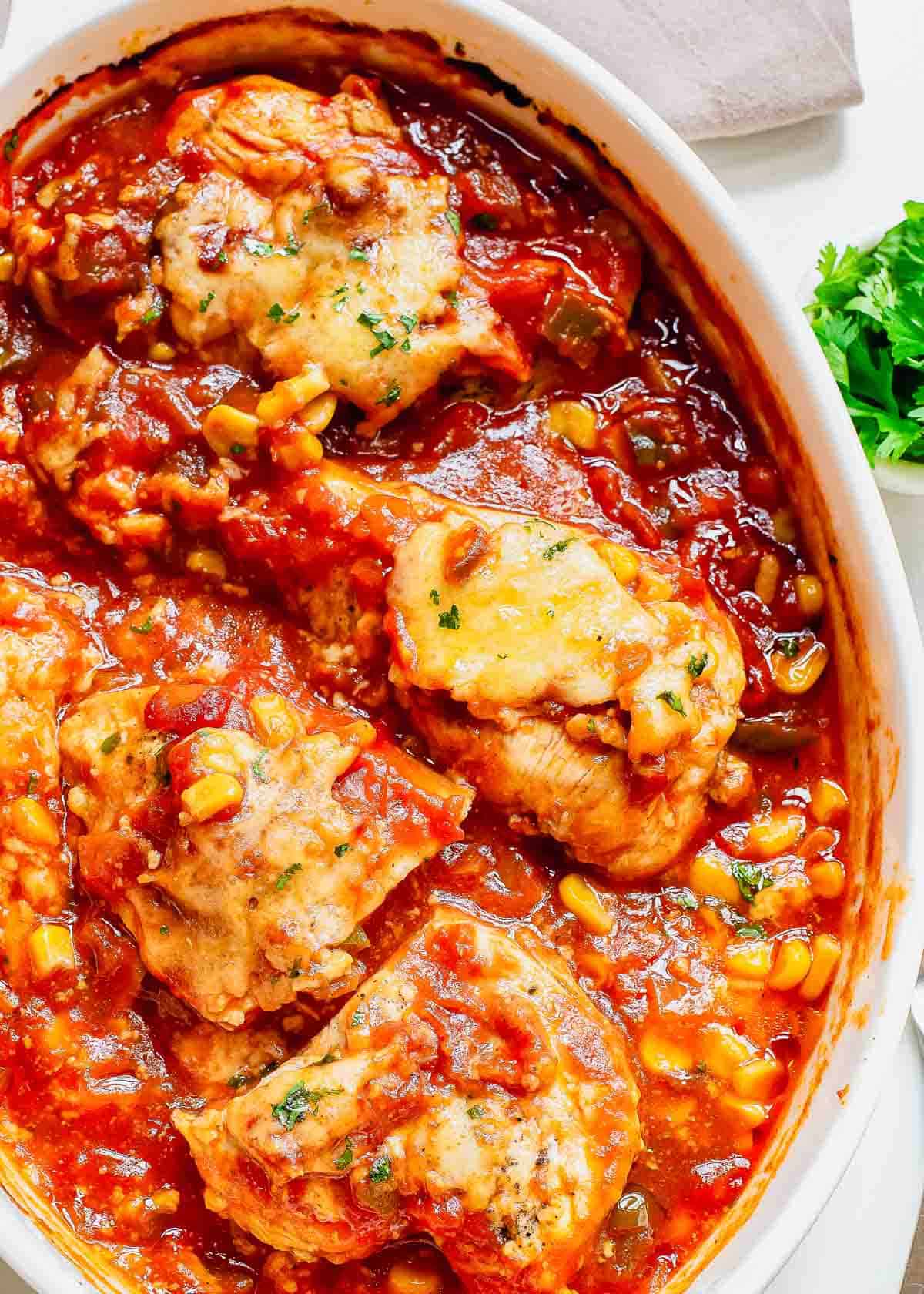 Overhead shot of a salsa chicken recipe in a white casserole dish.