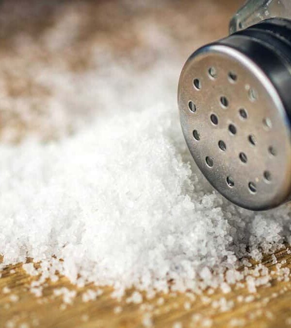 A salt shaker on a wooden table.