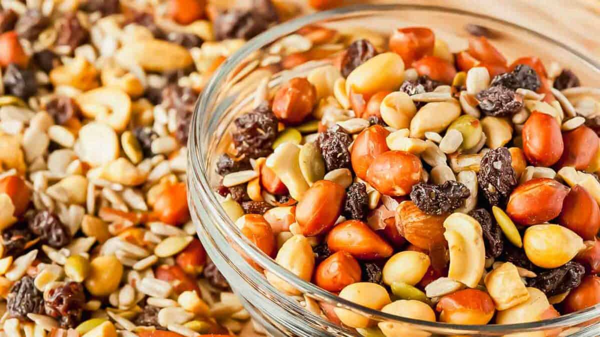 Nuts and seeds in a bowl on a wooden table.