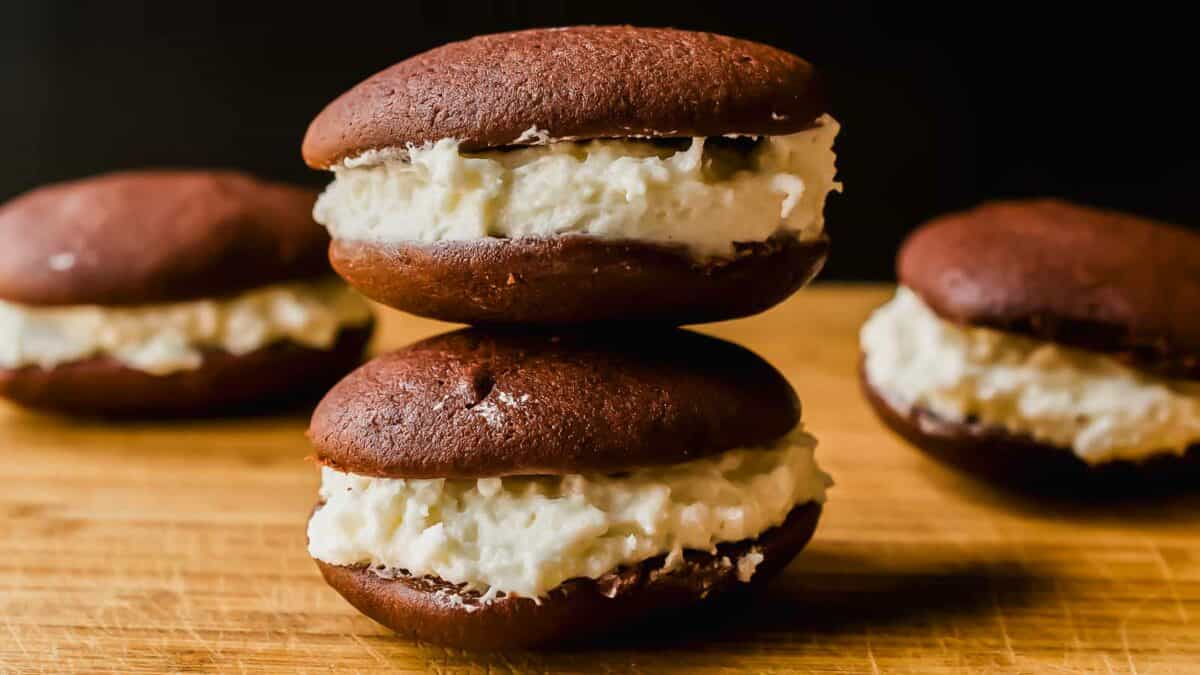 A stack of chocolate whoopie pies with white frosting.