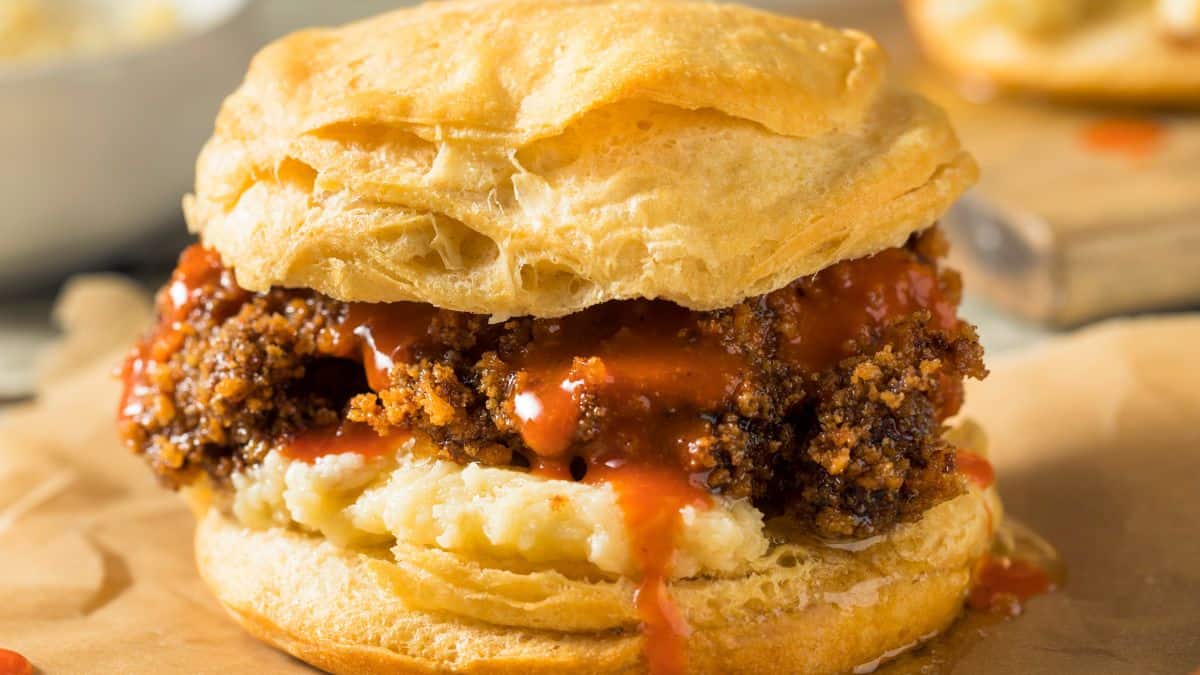 A biscuit sandwich with a crispy breaded meat patty and sauce.