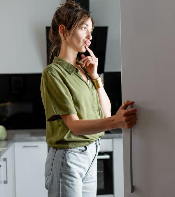 Woman thinking and looking away in a modern kitchen setting.